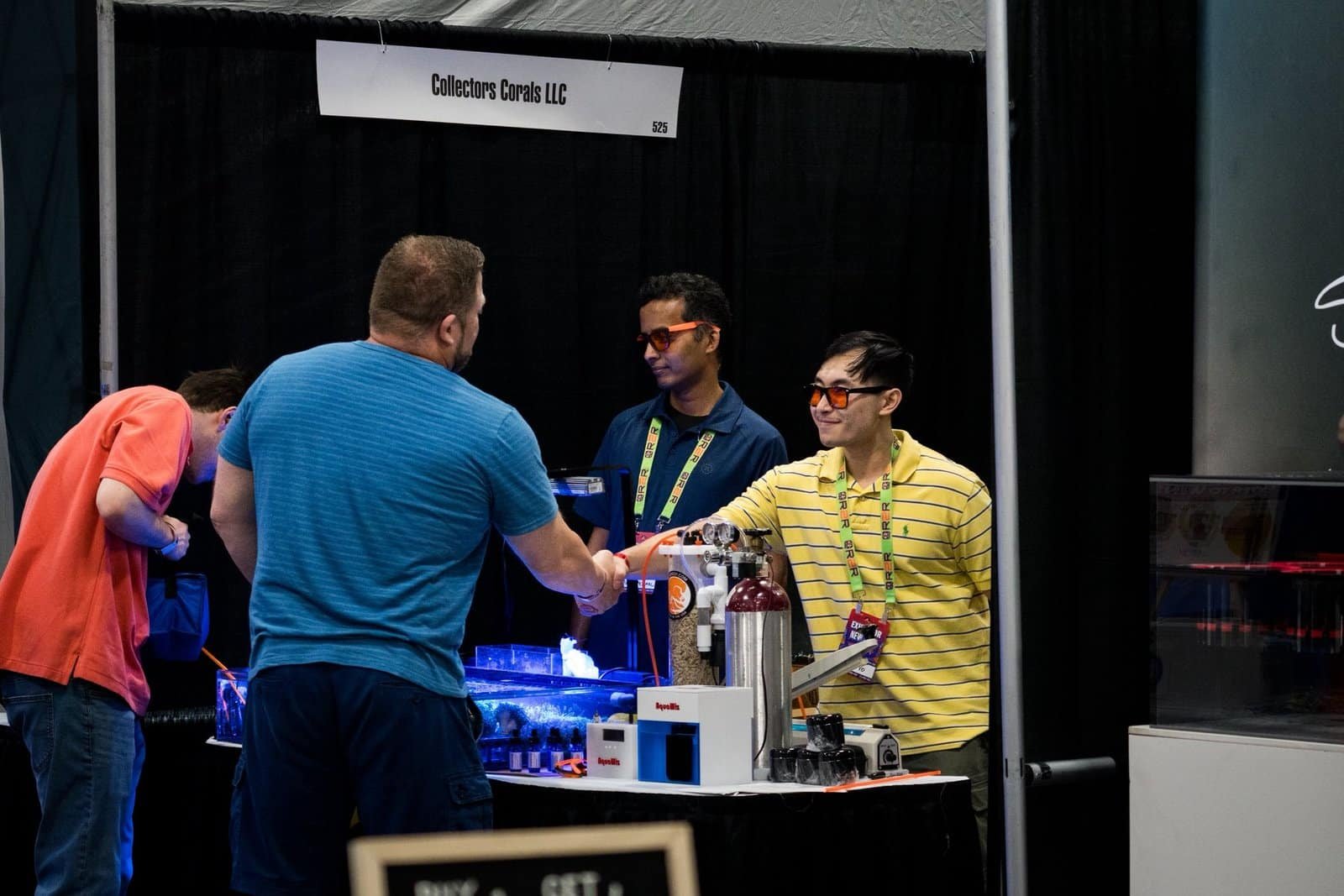 Photograph of a positive interaction at a event of two guys giving each other a handshake.