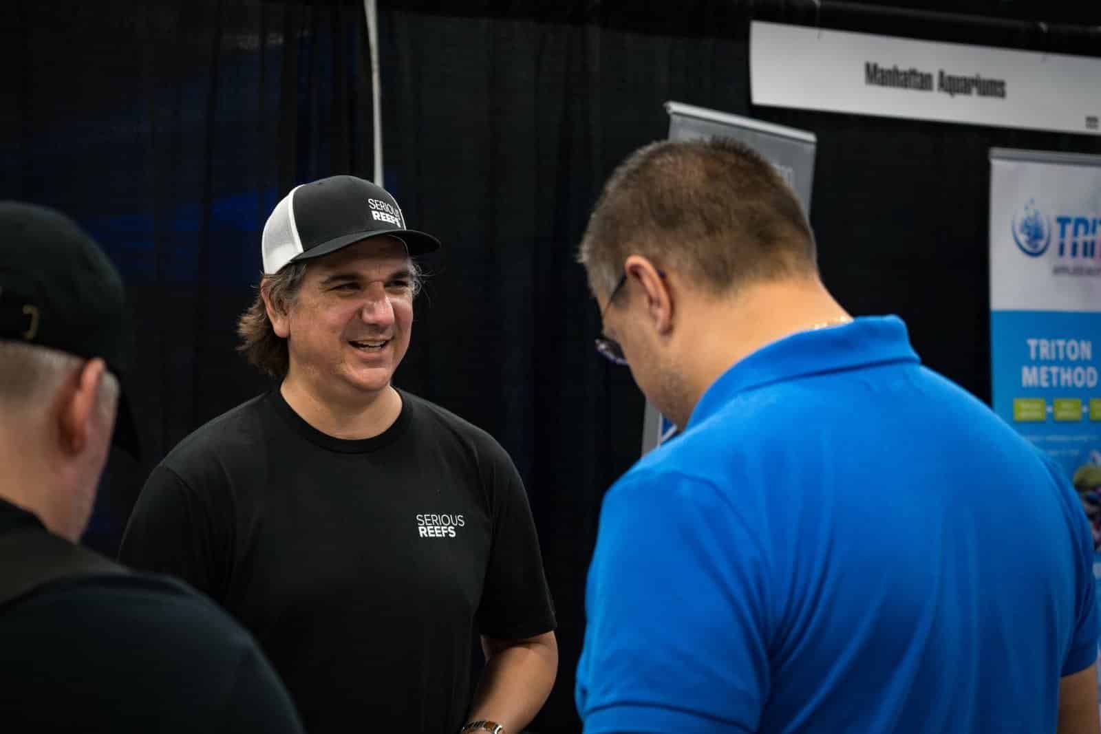 Photograph of 2 guys interacting with each other and having a conversation.