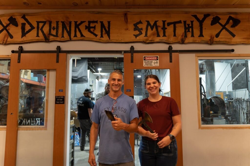 Photograph of a couple holding weapons they made.