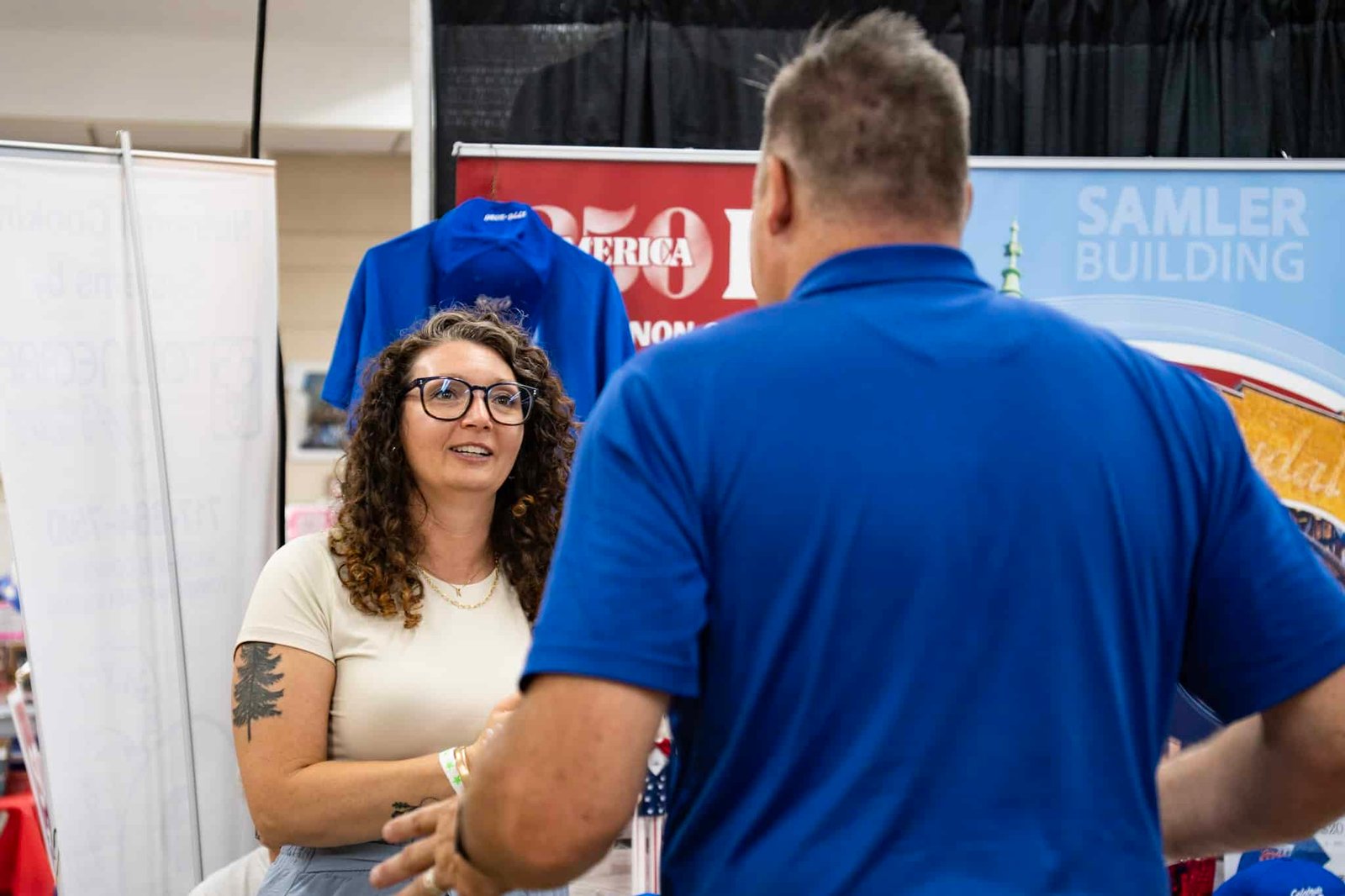 Photograph of 2 people interacting with each other having a conversation at an event.