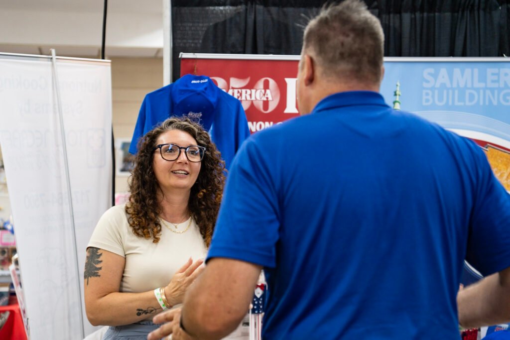 Candid Photograph of 2 people interacting with each other having a conversation at an event.