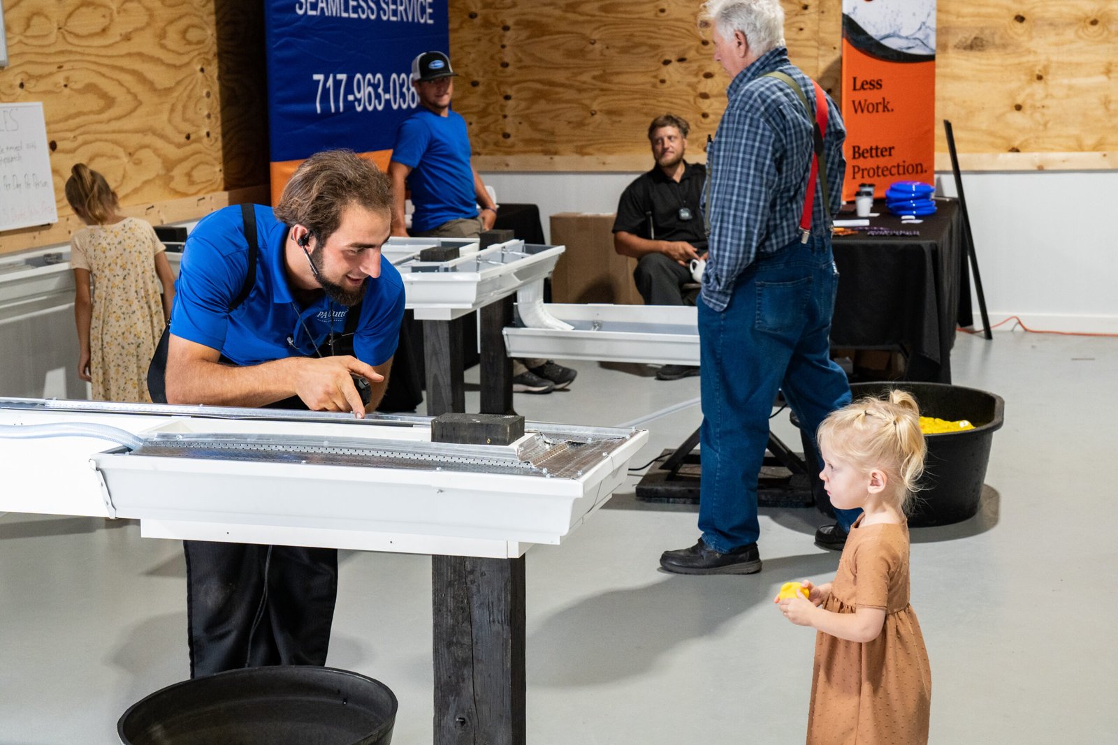 Photograph of man pointing at a gutter to direct a child to interact with the gutter.