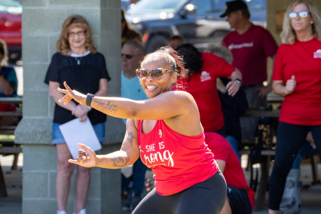 Lady dancing in front a of group of people at a event.