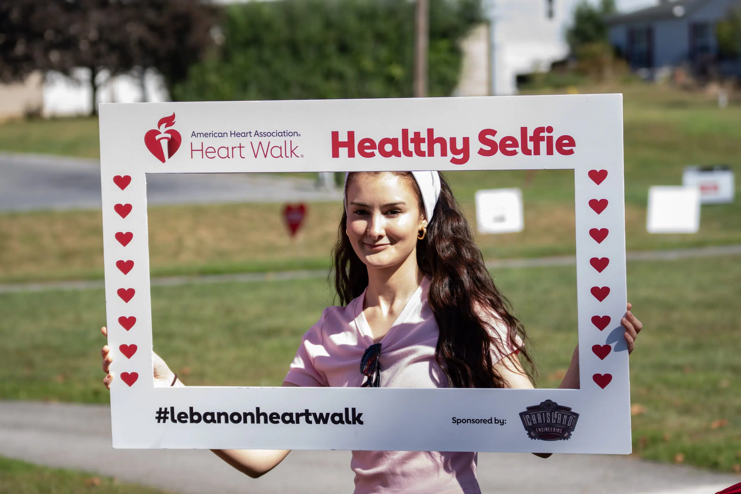 Girl holding a healthy selfie sign to take a photograph at the events.