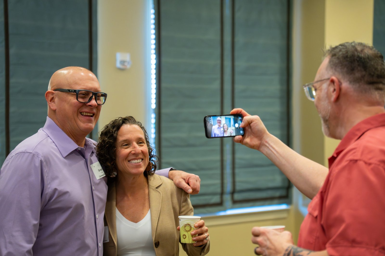 Friends posing for a photo together while another holds a camera